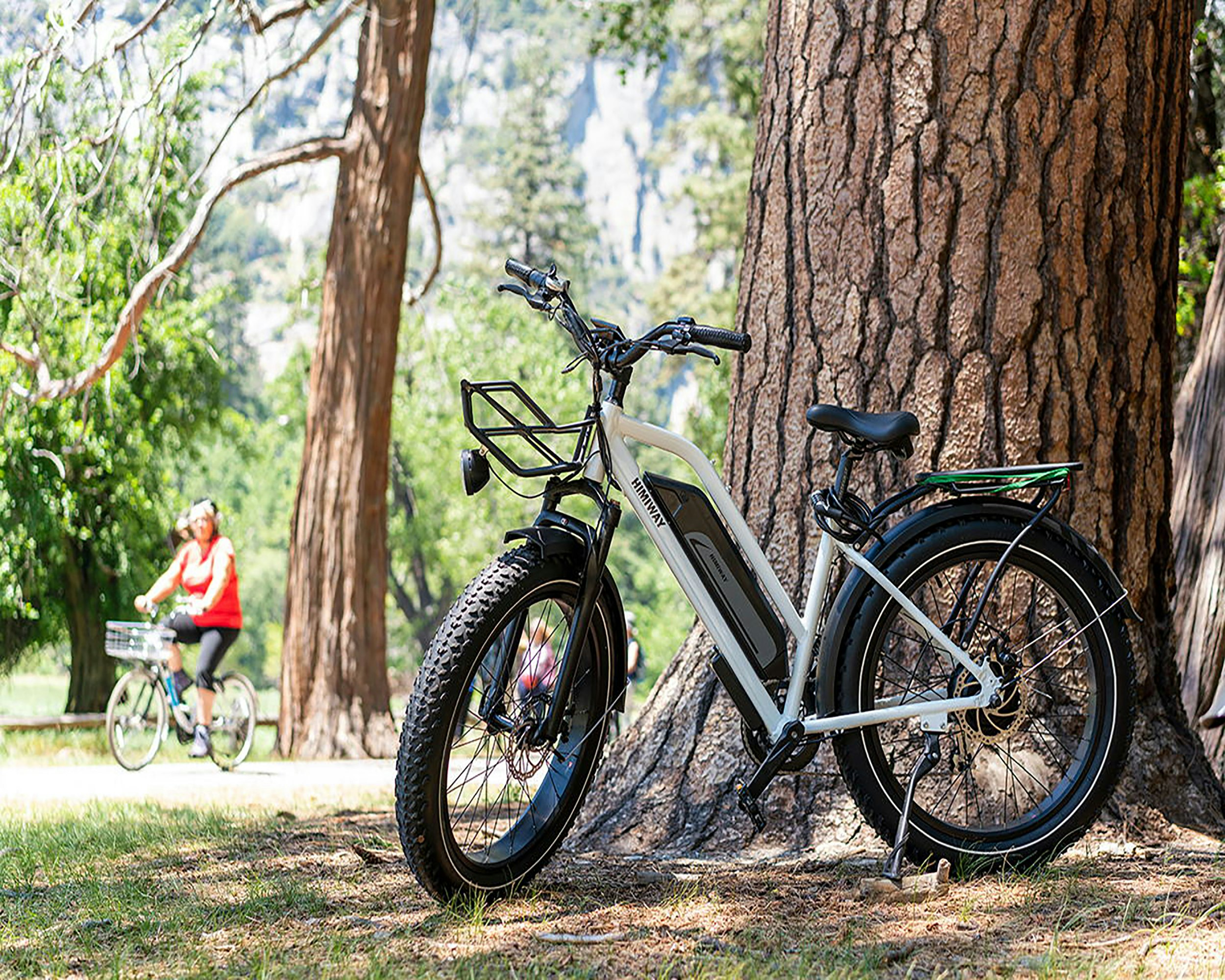 white and black mountain bike parked beside brown tree during daytime